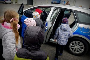 Policjanci na placu komendy rozmawiają z dziećmi o bezpieczeństwie