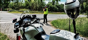 policjant kontroluje prędkość pojazdów przy przejściu dla pieszych