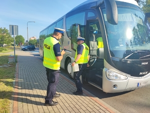policjanci z ruchu drogowego kontrolują autobusy