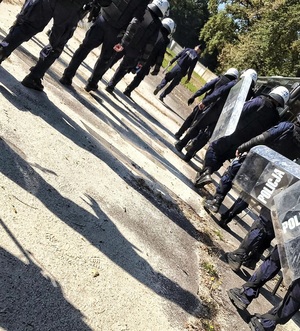 na zdjęciu jedenastu umundurowanych policjantów ze sprzętem wykorzystywanym podczas działań przez pododdziały zwarte