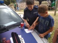 Policjantka pobiera pamiątkowy odcisk palca dziecka