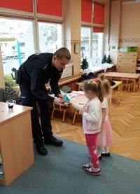 Dzieci wręczają policjantowi podziekowanie
