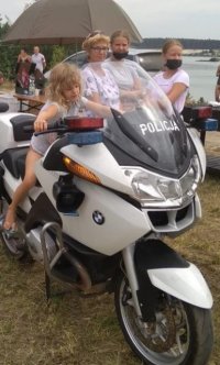 Mała dziewczynka siedzi na policyjnym motorze.