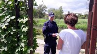 policjant rozmawia z działkowiczką o bezpieczeństwie na terenie ogrodów działkowych