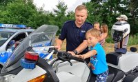 policjant pokazuje dziecku funkcje motocykla
