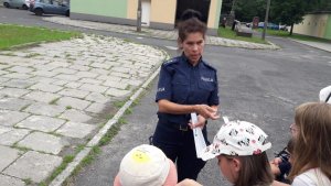 policjantka wręcza dzieciom odblaski