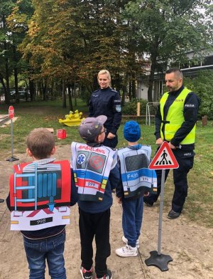 Policjanci rozmawiają na podwórku z przedszkolkami