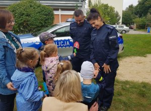 Policjanci rozmawiają na podwórku z przedszkolkami