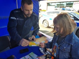 Policjanci rozmawiają z mieszkańcami przy policyjnym stoisku