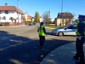 Umundurowani policjanci nadzorują dbają o bezpieczeństwo na drogach w rejonie zmantarza