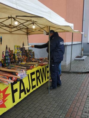 Policjant kontroluje stoisko z fajerwerkami