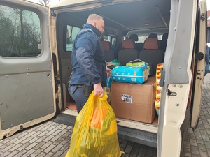 policjant pakuje zgromadzone rzeczy do busa