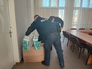 policjanci noszą rzeczy zgromadzone dla uchodźców