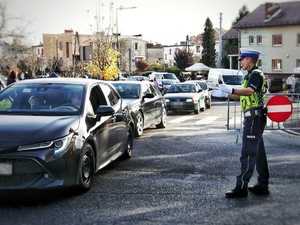na zdjęciu policjant kierujący ruchem oraz samochody