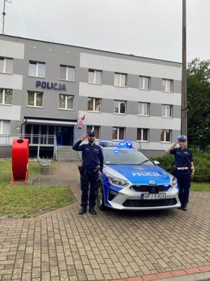 policjanci salutują przed komendą oddając hołd bohaterom powstania warszawskiego