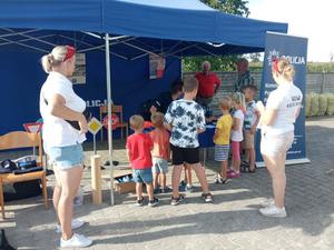 policjantka rozmawia z uczestnikami pikniku