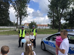 policjanci ruchu drogowego stoją przed szkołą