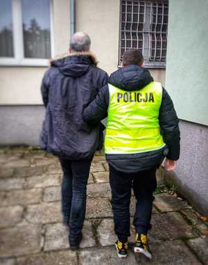 Policjant prowadzi zatrzymanego