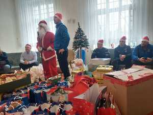 Mikołaj stoi w pokoju, obok choinki