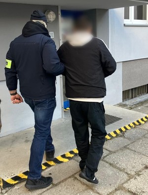 Policjant prowadzi zatrzymanego