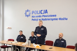 Policjanci i przedstawiciele służb siedzą na sali konferencyjnej przy stołach