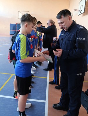 Turniej piłki nożnej. Komendant wręcza uczestnikom nagrodę.