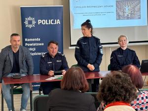 grafika przedstawia policjantów oraz uczestników debaty w sali konferencyjnej
