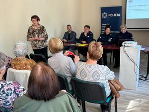 grafika przedstawia policjantów oraz uczestników debaty w sali konferencyjnej