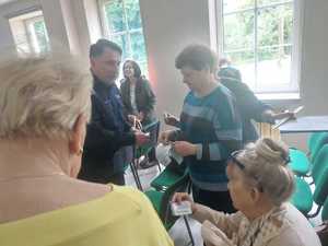 grafika przedstawia policjantów oraz uczestników debaty w sali konferencyjnej
