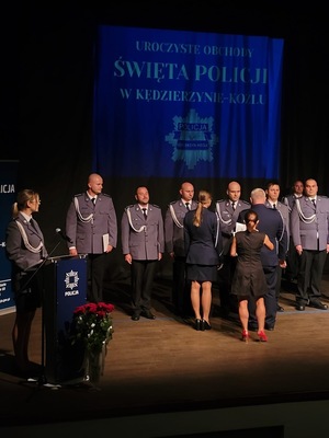 zdjęcie kolorowe - przedstawiające sylwetki funkcjonariuszy na scenie