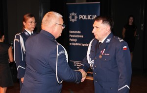 zdjęcie kolorowe - przedstawiające sylwetki funkcjonariuszy na scenie