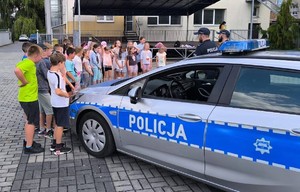 zdjęci kolorowe - funkcjonariusze z dziećmi na półkolonii