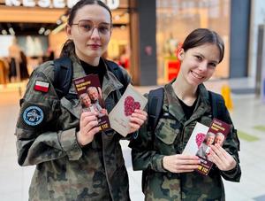 policjanci z uczniami rozdający ulotki w galerii handlowej