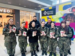 policjanci z uczniami rozdający ulotki w galerii handlowej