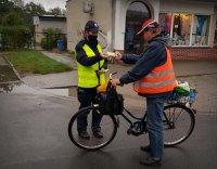 Policjantka na ulicy wręcza rowerzyście odblask