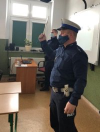 Policjant pokazuje dzieciom tarczę do zatrzymywania pojazdów